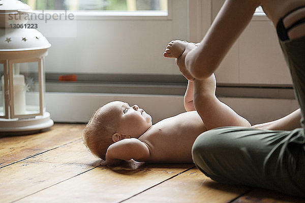 Ausgeschnittenes Bild einer Mutter  die ihr Mädchen zu Hause auf dem Boden ausübt