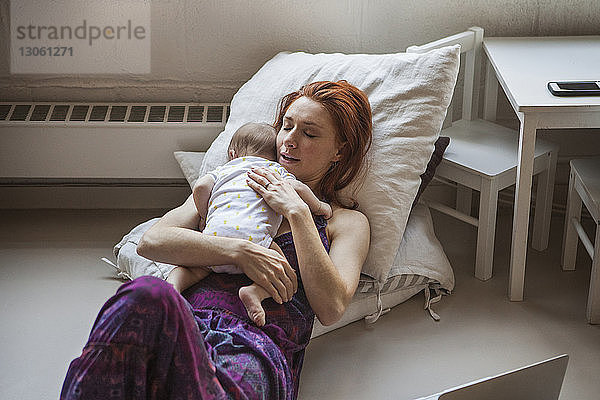 Hochwinkelaufnahme einer Mutter  die zu Hause mit einem kleinen Mädchen schläft