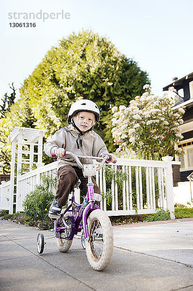 Porträt eines Jungen auf dem Fahrrad auf einem Fußweg