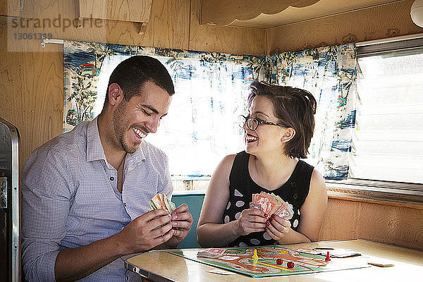 Glückliches Paar spielt Brettspiel  während es im Wohnmobil sitzt