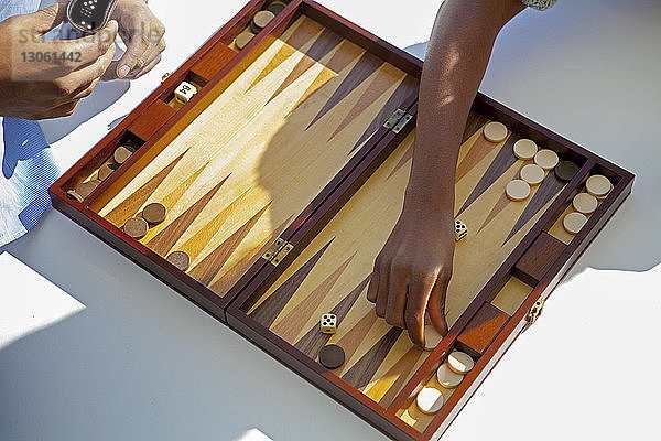 Ausgeschnittenes Bild eines Backgammon spielenden Paares zu Hause