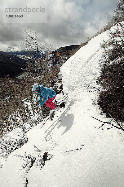 Seitenansicht einer Frau beim Skifahren am Berg