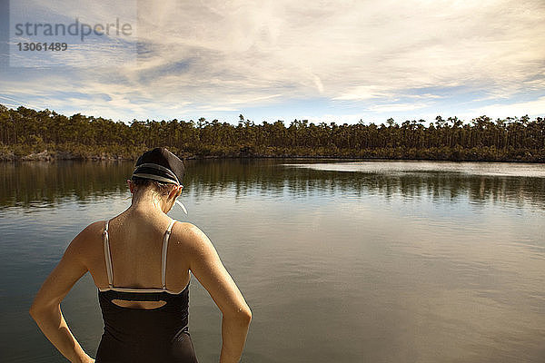 Rückansicht einer am See stehenden Frau in Badebekleidung