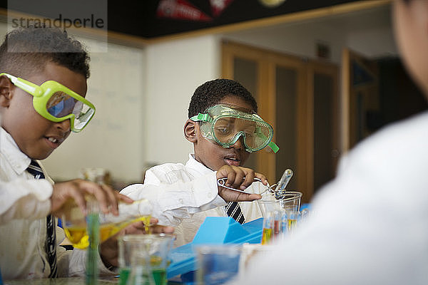 Schüler mischen Chemikalien am Tisch im Labor