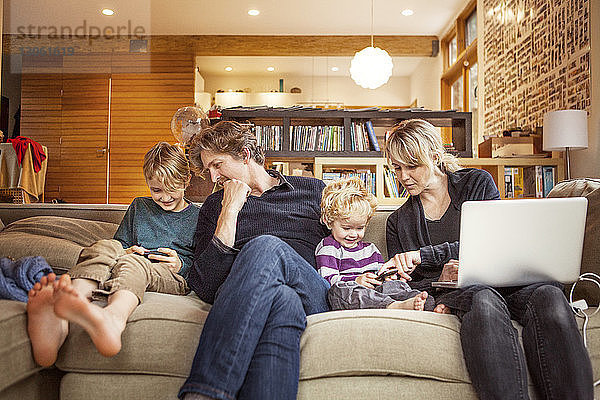 Glückliche Familie sitzt zu Hause auf dem Sofa