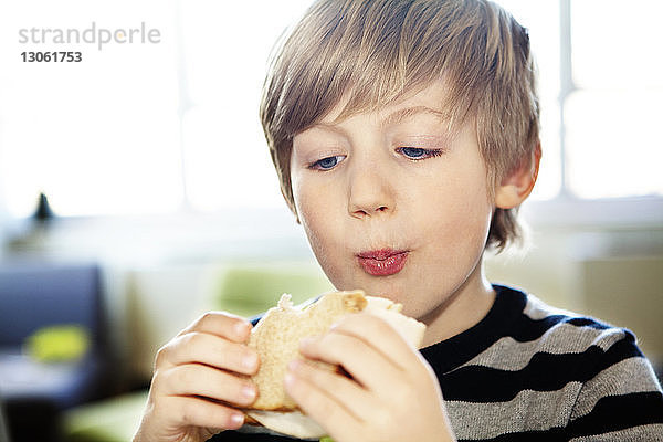 Nahaufnahme eines Jungen  der zu Hause ein Sandwich isst