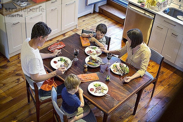 Hochwinkelansicht einer Familie  die am Esstisch in der Küche isst