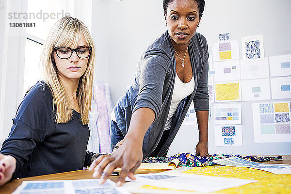 Modedesignerinnen überprüfen Papiere auf dem Tisch im Workshop