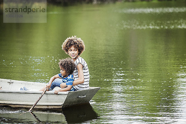 Junge mit Schwester beim Bootfahren auf dem See