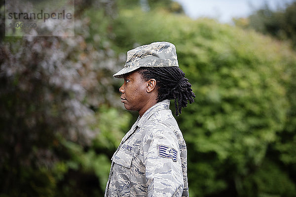 Profilansicht einer Soldatin  die an Bäumen steht