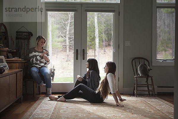 Familie spricht  während sie zu Hause an der Tür sitzt