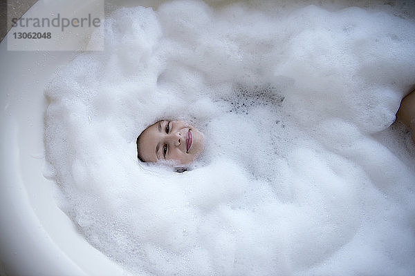 Hochwinkelansicht eines in der Badewanne liegenden Mädchens