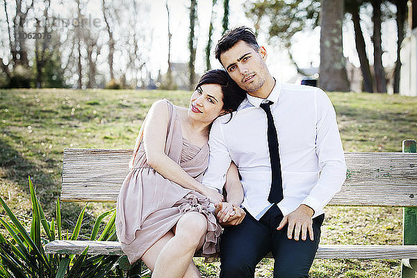 Porträt eines glücklichen Paares auf einer Parkbank sitzend