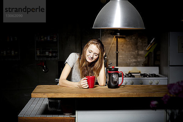 Junge Frau trinkt Kaffee in der Küche