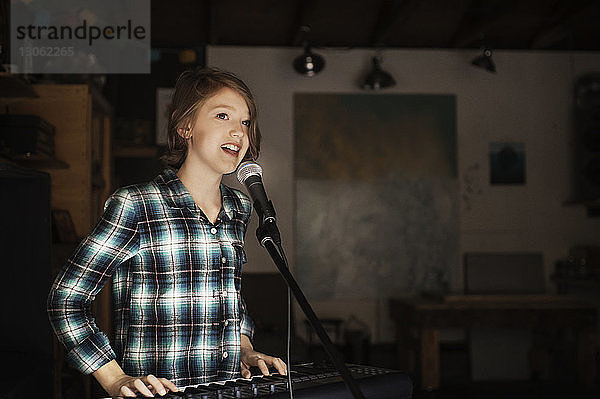 Mädchen singt und spielt Klavier im Aufnahmestudio