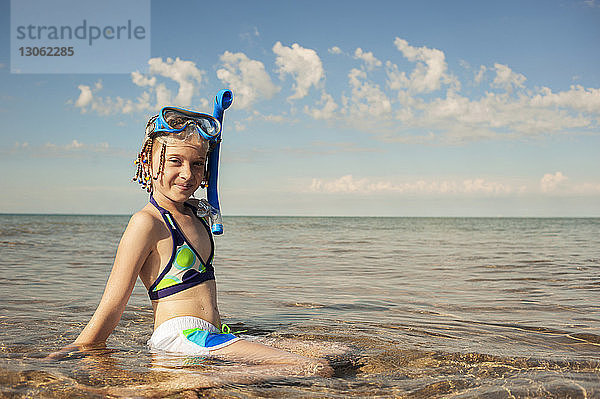 Porträt eines glücklichen Mädchens im Meer an einem sonnigen Tag