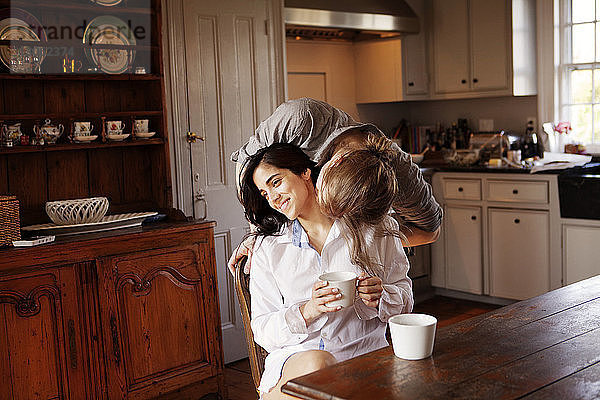 Mann küsst Freundin in Küche