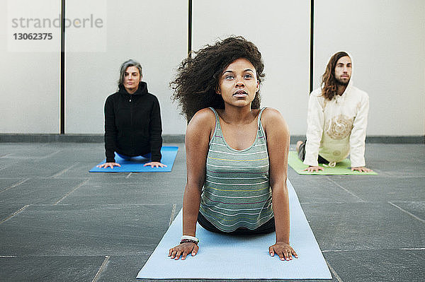 Freunde üben Kobra-Pose im Yoga-Kurs