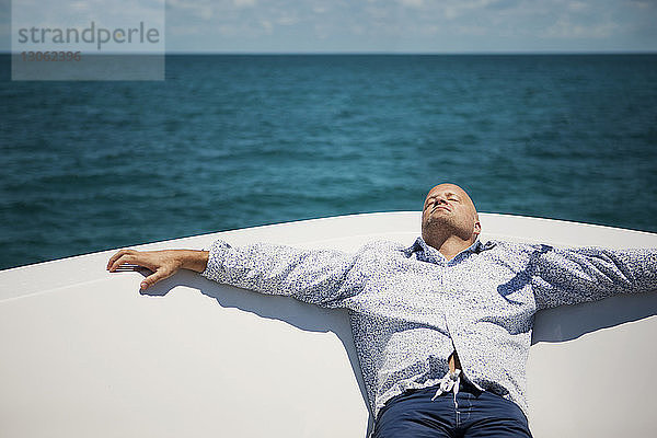 Mann entspannt sich an Deck einer Yacht
