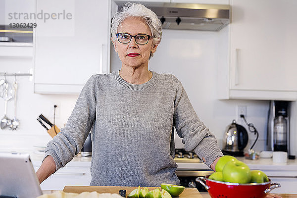 Porträt einer selbstbewussten Frau  die in der Küche steht