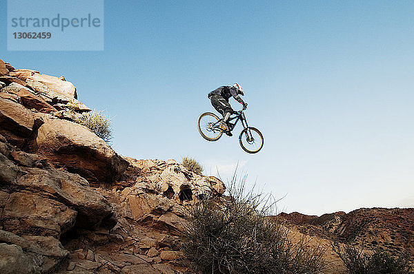 Niedrigwinkelansicht eines Mountainbikers bei einem Stunt in der Luft