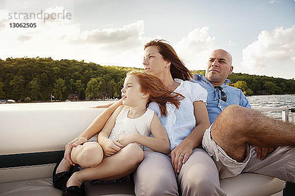 Mädchen entspannt sich mit den Eltern während einer Bootsfahrt auf dem See