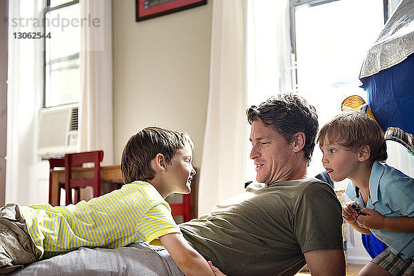 Glücklicher Vater entspannt sich mit Söhnen zu Hause