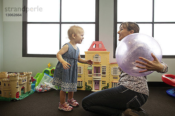 Kindermädchen und Mädchen spielen in der Vorschule mit dem Ball