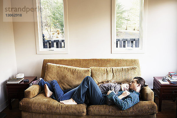 Hochwinkelansicht eines Paares  das zu Hause auf dem Sofa schläft