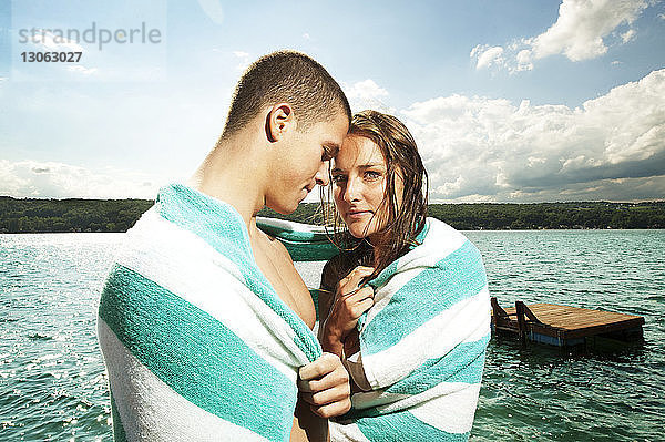 Romantisches Paar in ein Handtuch gewickelt am See