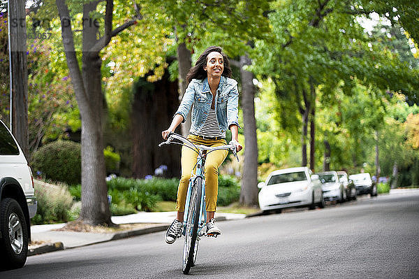 Frau schaut weg  während sie auf der Straße Fahrrad fährt