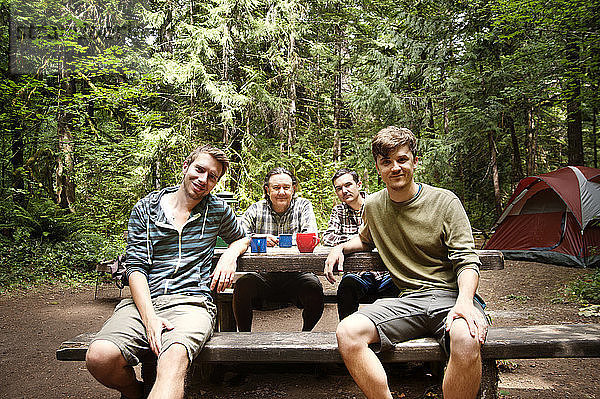 Porträt einer Familie  die im Wald zu Tisch sitzt