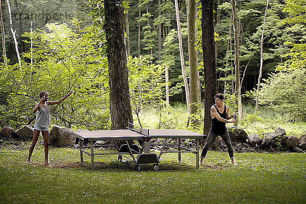 Paar spielt Tischtennis im Wald