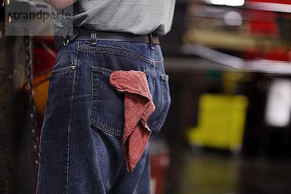 Mittendrin Jeans tragender Mann mit Serviette in der Tasche