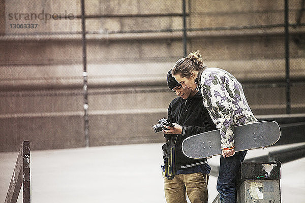 Freunde schauen in die Kamera  während sie im Skateboard-Park stehen