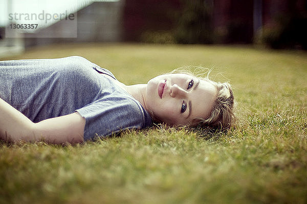 Porträt einer auf einem Grasfeld liegenden Frau