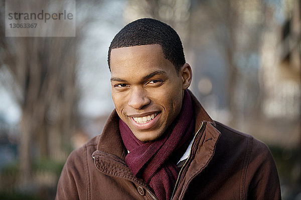 Porträt eines lächelnden jungen Mannes im Freien