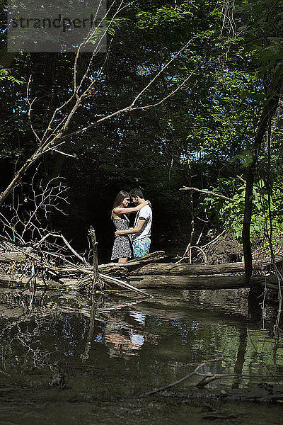 Romantisches Paar umarmt sich im Wald stehend