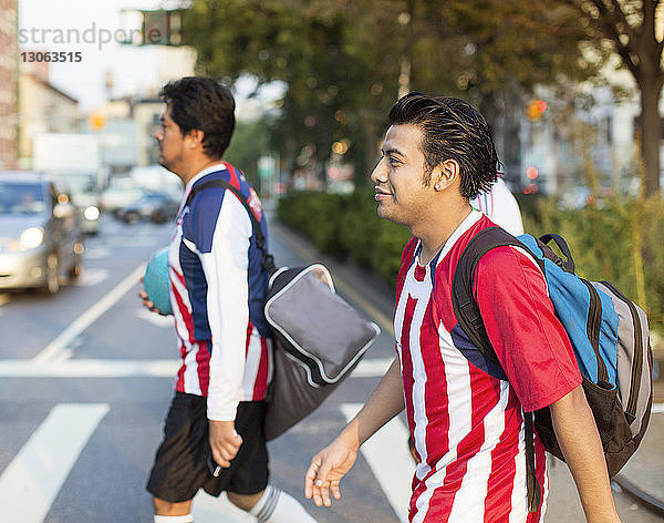 Fußballspieler überqueren Straße in der Stadt