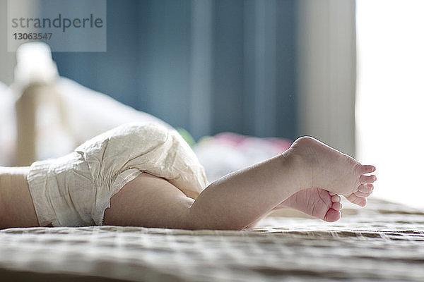 Niedriger Querschnitt eines zu Hause auf dem Bett liegenden Mädchens