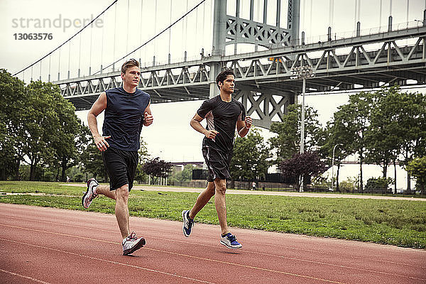 Freunde laufen auf der Sportbahn gegen die Triborough-Brücke