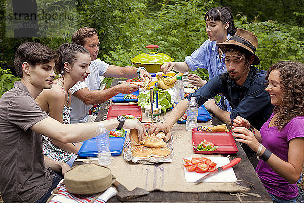 Freunde beim Frühstücken am Picknicktisch im Wald