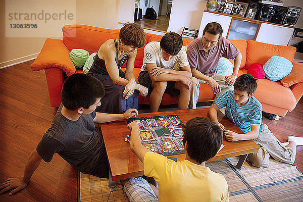 Hochwinkelansicht einer Familie  die das Spiel im Wohnzimmer genießt