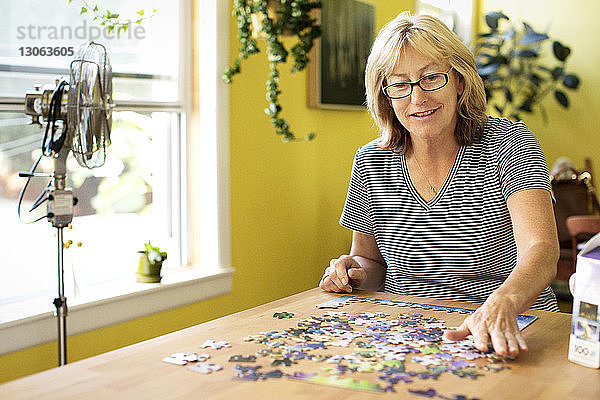 Frau spielt zu Hause Puzzle