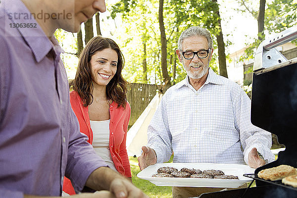 Glückliche Familie genießt Barbecue-Grill im Rasen