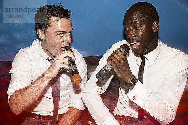 Freunde singen Karaoke in einem Nachtclub