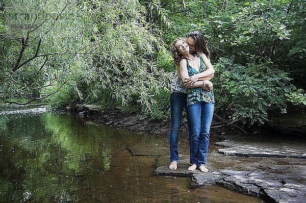 Glückliche Freunde stehen am See im Wald