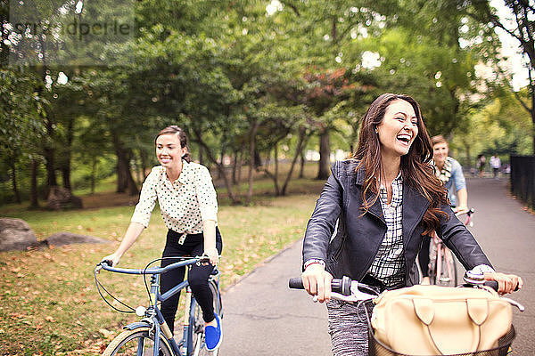 Glückliche Freunde radeln auf der Straße im Central Park