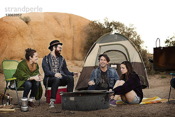 Glückliche Freunde genießen auf dem Campingplatz