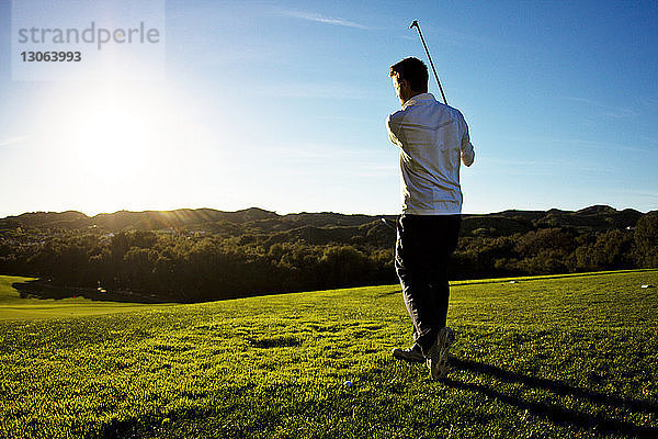 Rückansicht eines Golf spielenden Mannes bei klarem Himmel